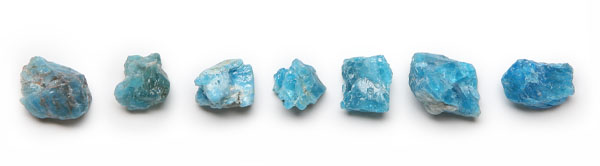 Niebieski kamień Apatyt, migoczący w promieniach słońca, symbolizujący harmonię i duchowy rozwój, otoczony naturalnym krajobrazem.